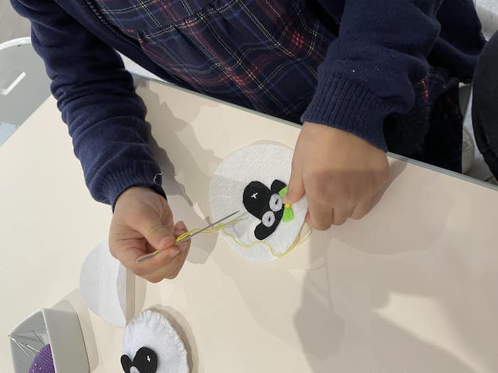 Une petite fille confectionne un mouton en laine lors d'un atelier montessori a l'espieglerie