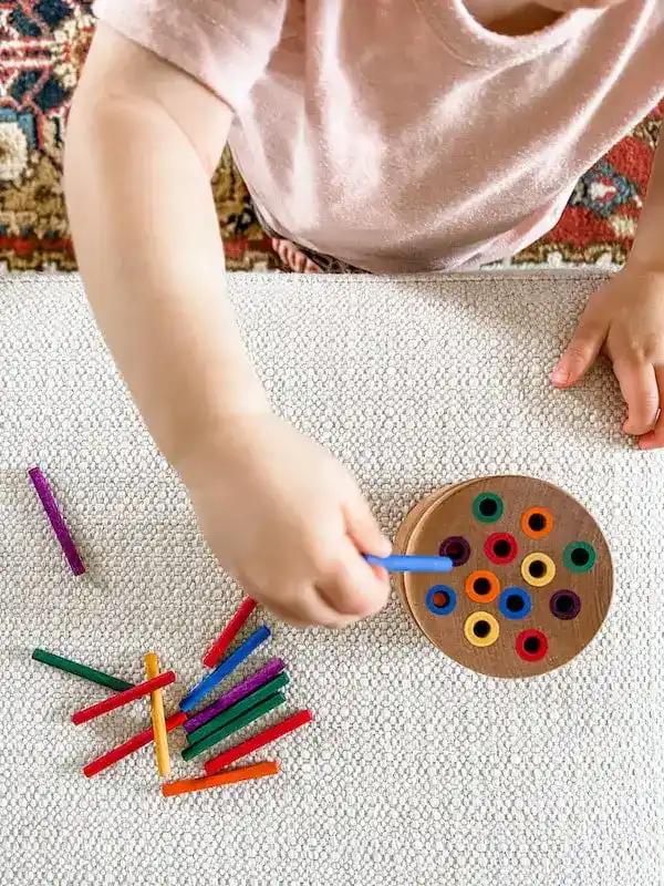 Main d'un enfant faisant une actitvité d'association Montessori d'association de couleurs à Toulouse