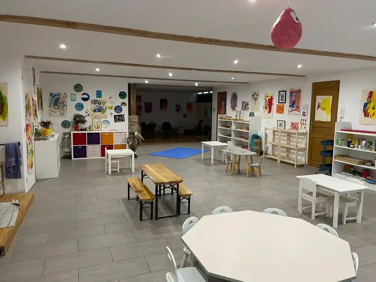 Salle principale de l'Espièglerie qui montre des tables dans une salle spacieuse